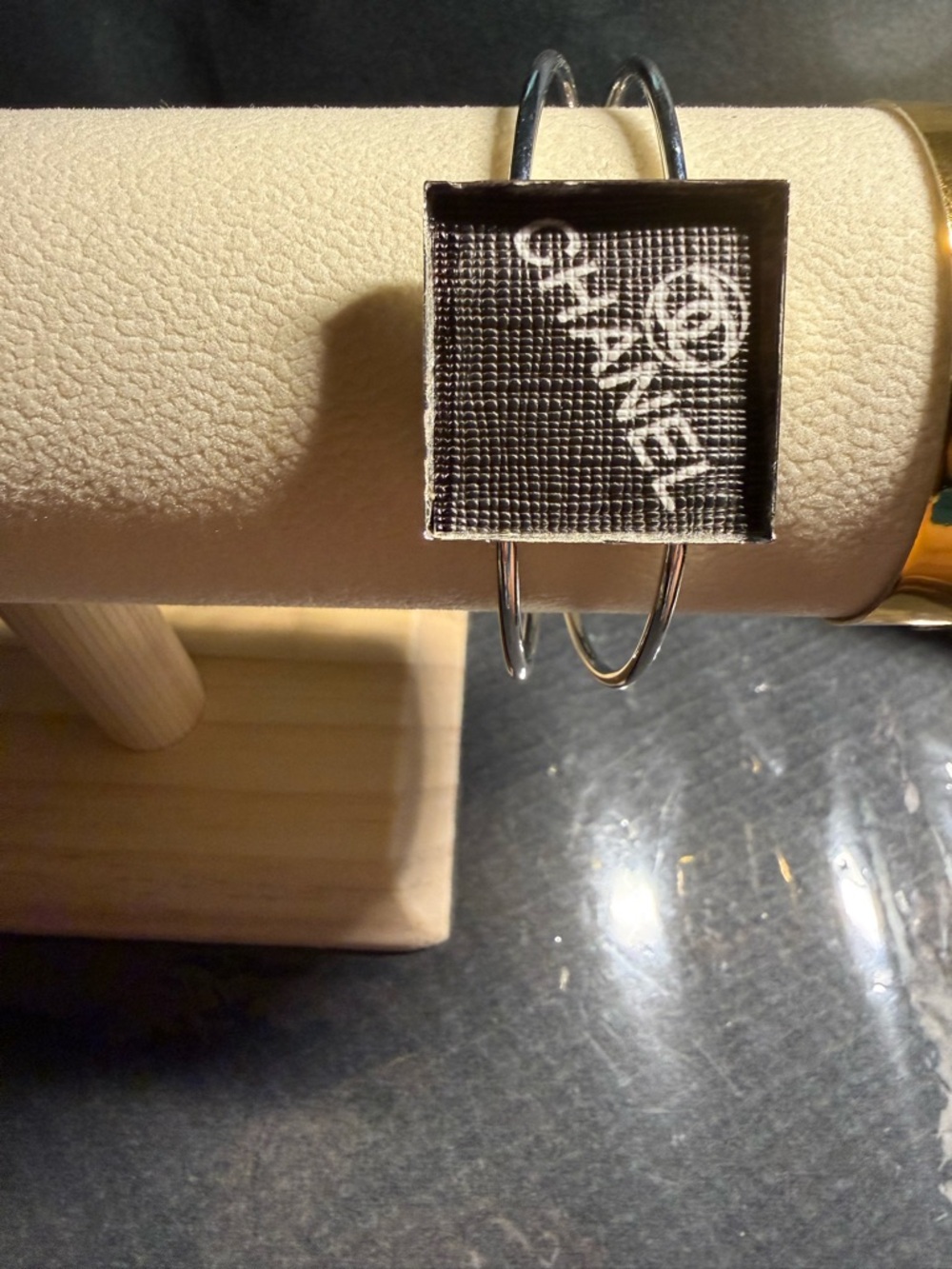 Brand New Silver Bangle with Black Square Logo Plaque. Good Buy